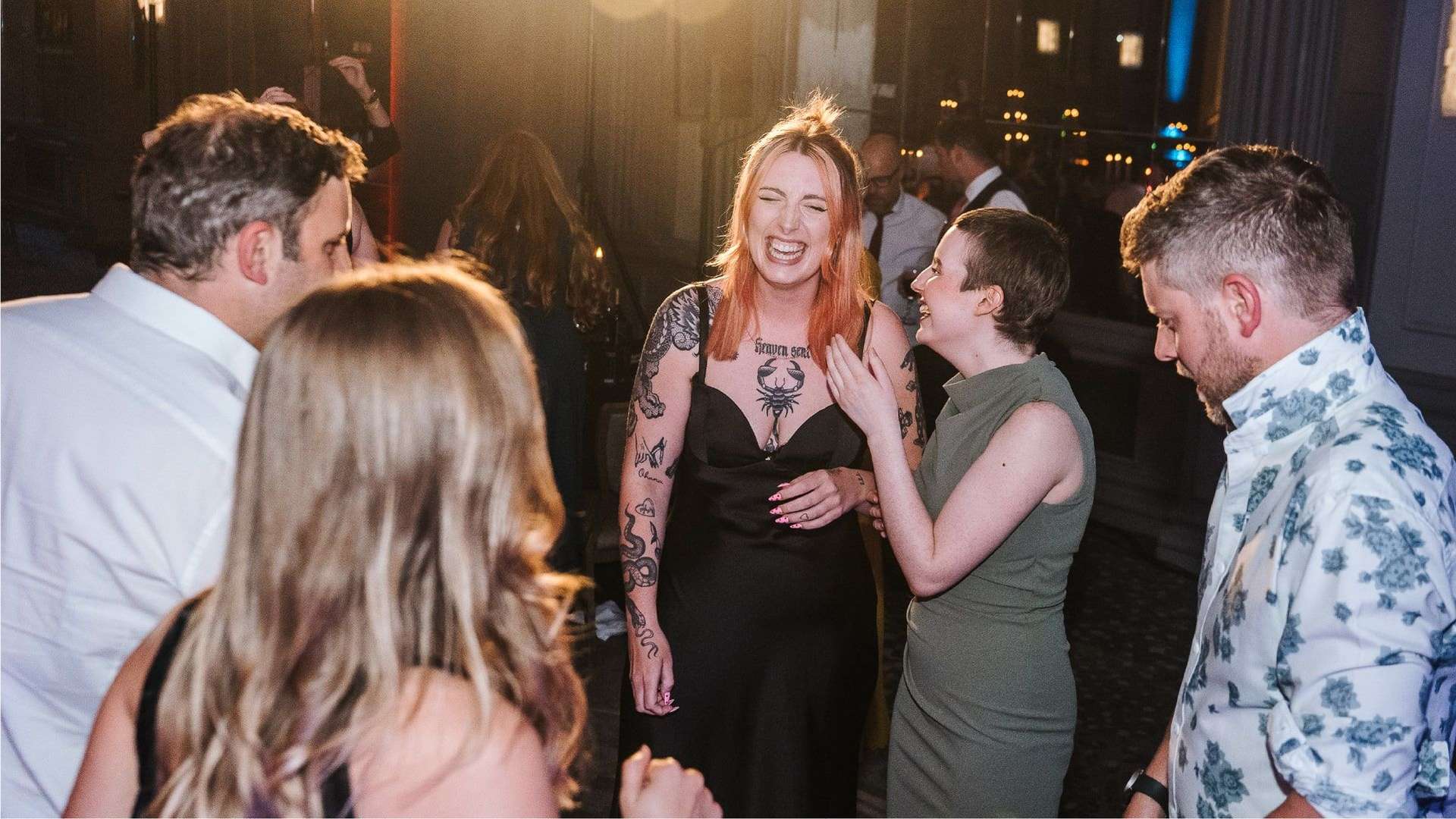 People smiling on a dance floor. Great Place to Work logo