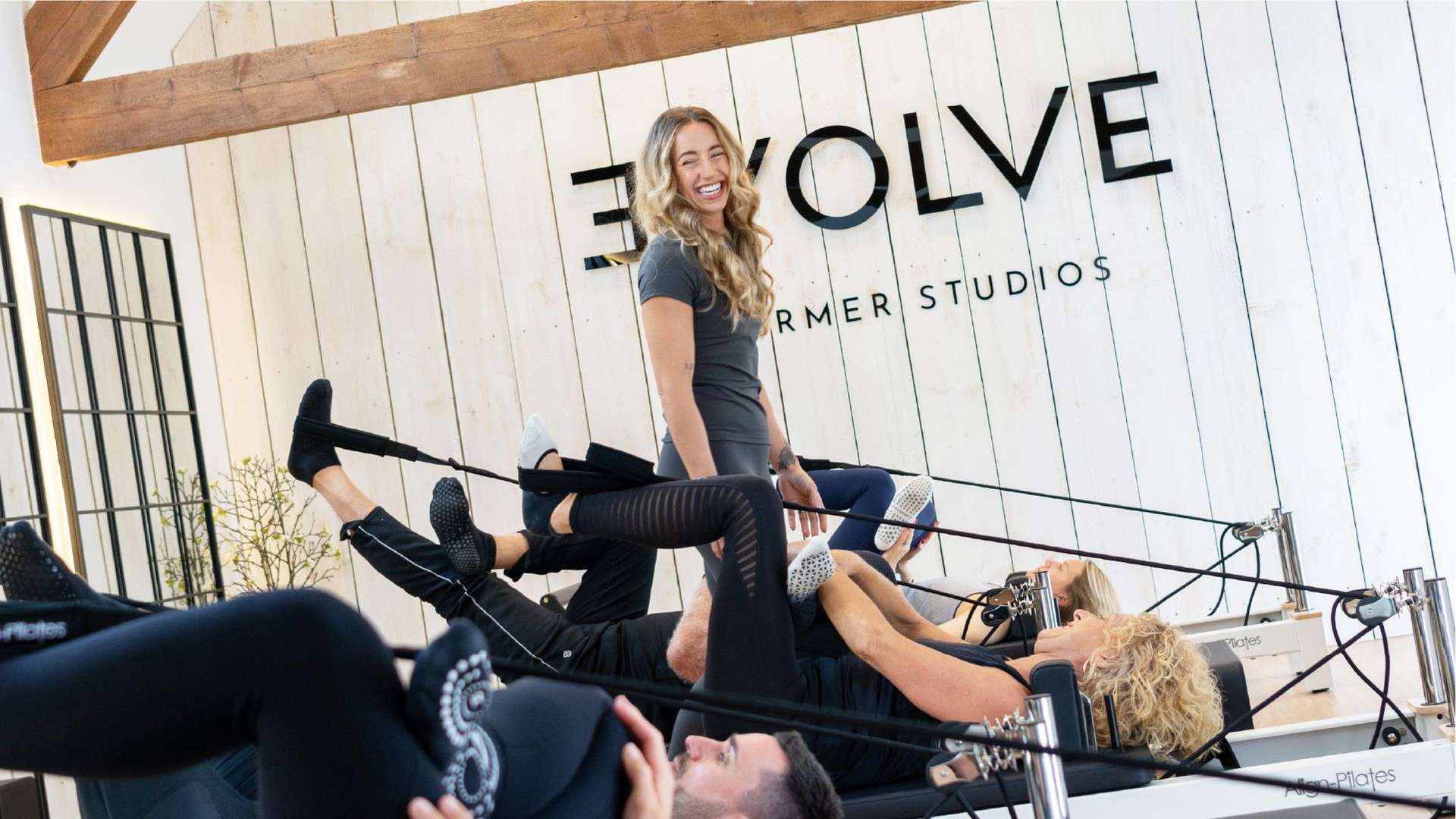 Photo of evolve clients in action in the studio, with instructor smiling