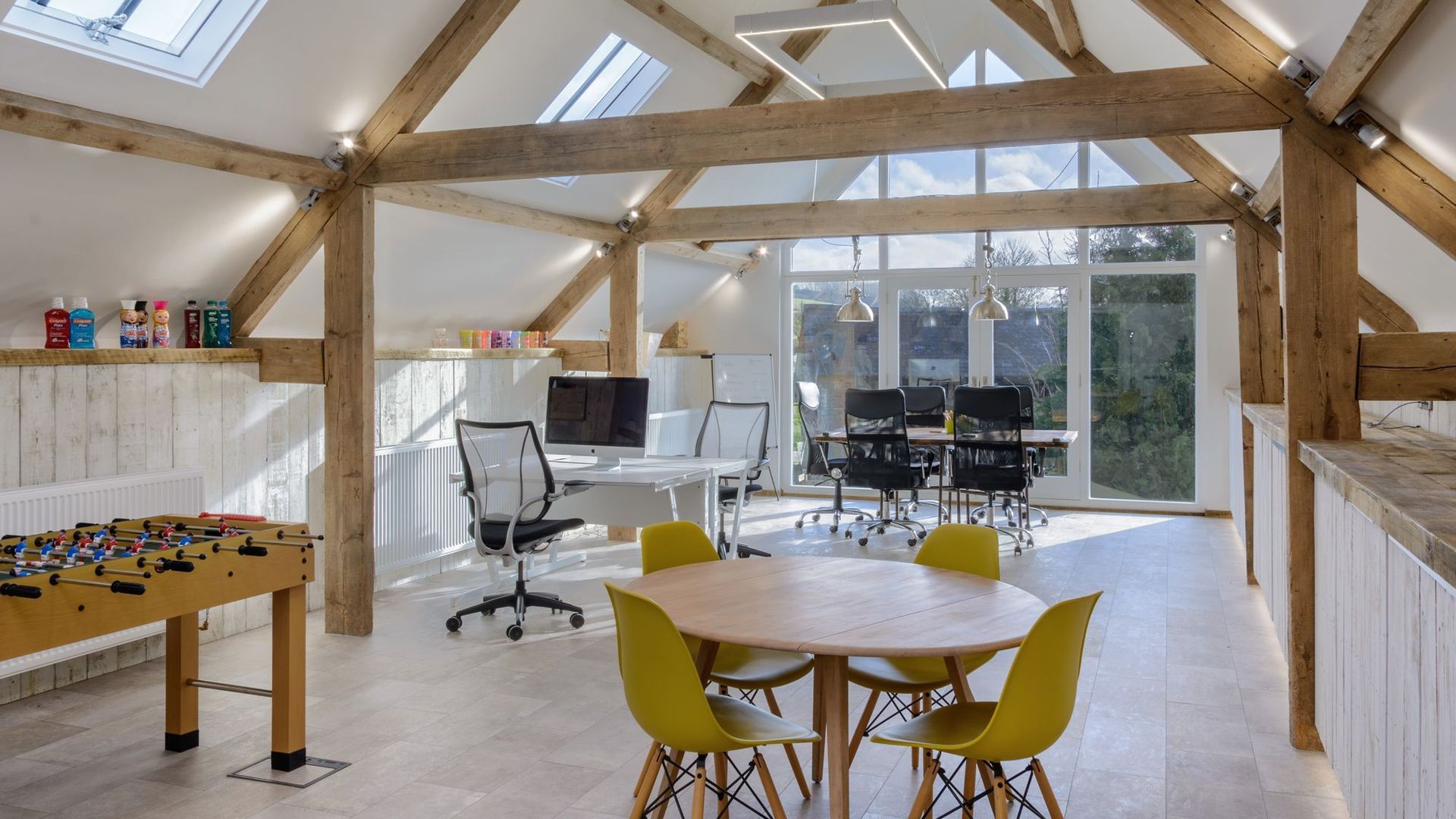The upstairs of the Ergo office, showing 3 desks and a table football table