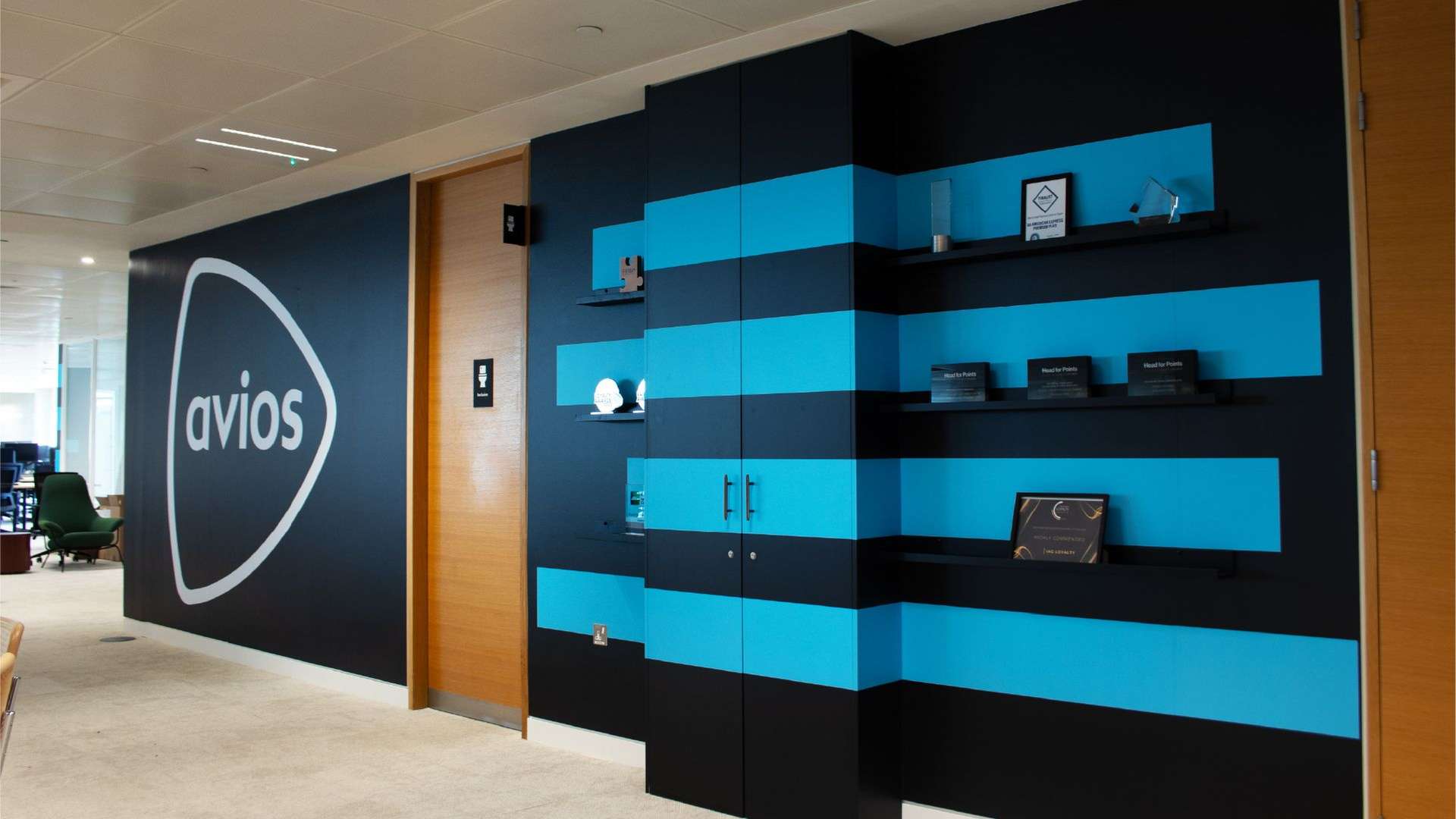Avios logo and trophy shelves on the wall of an office space