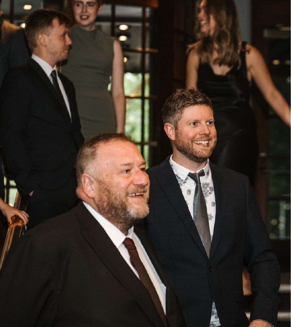 Justin and Tom smiling off camera